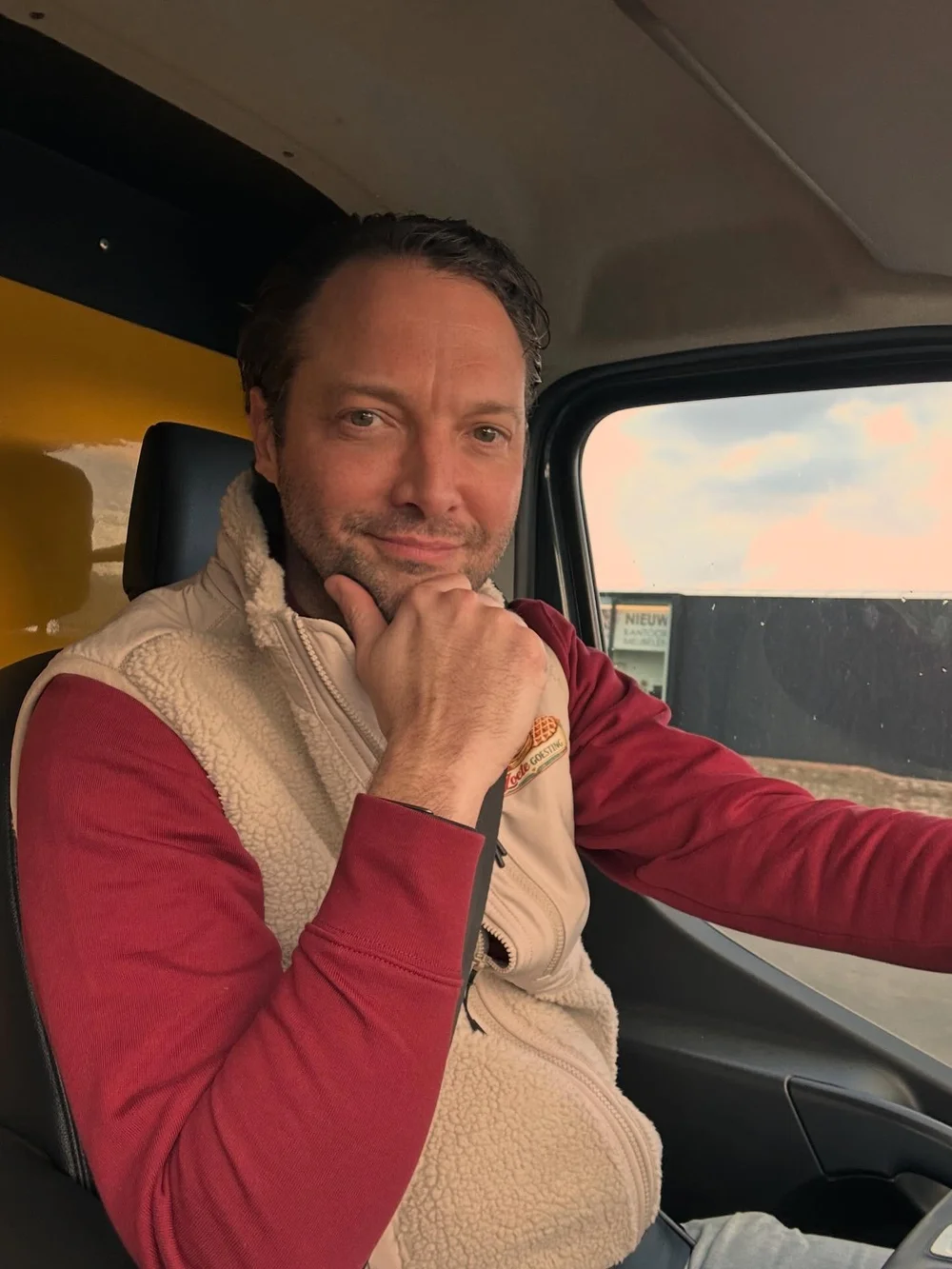 Kristof achter het stuur van de foodtruck, met zijn hand onder de kin